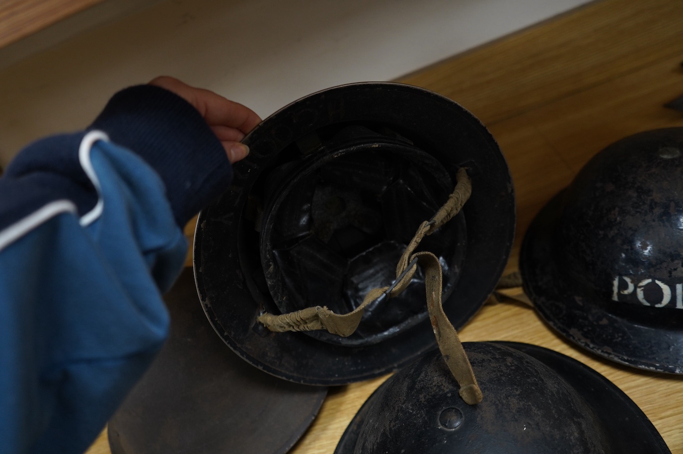 Seven early to mid 20th century military tin helmets; including one stencilled with POLICE. Condition - poor to fair.